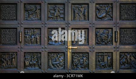 Una grande porta in bronzo della chiesa di Grossmunster con pannelli decorati scolpiti raffiguranti scene della riforma installata nel 1938 a Zurigo, in Svizzera Foto Stock