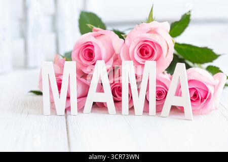 rosa (specifica Rosa), lettere MAMA davanti a un mazzo di fiori rosa, immagine simbolica della festa della mamma Foto Stock