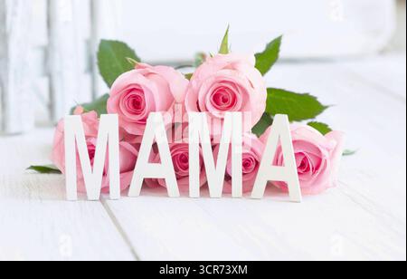 rosa (specifica Rosa), lettere MAMA davanti a un mazzo di fiori rosa, immagine simbolica della festa della mamma Foto Stock