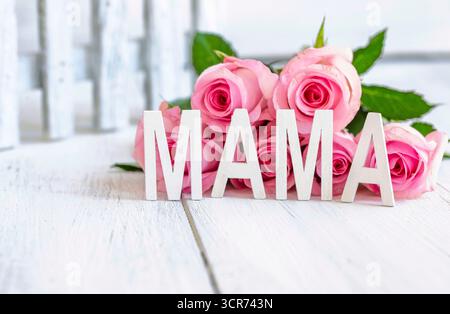 rosa (specifica Rosa), lettere MAMA davanti a un mazzo di fiori rosa, immagine simbolica della festa della mamma Foto Stock