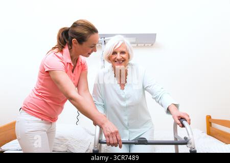 un assistente geriatrico che si occupa di un anziano cittadino Foto Stock