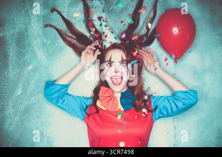 Donna dai capelli rossi in costume di Halloween, clown horror Foto Stock