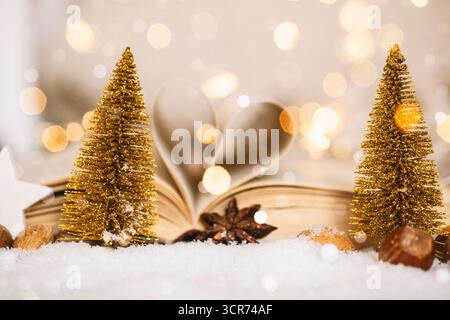 Alberi di Natale fatti di filo e libro aperto con pagine piegate come un cuore nella decorazione natalizia Foto Stock