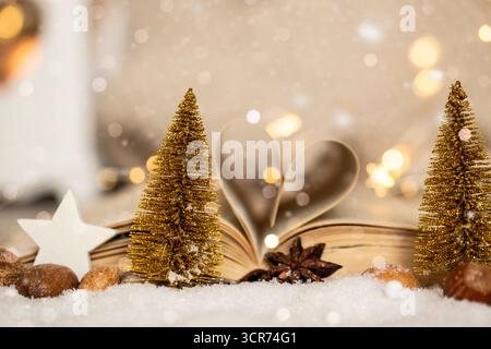 Alberi di Natale fatti di filo e libro aperto con pagine piegate come un cuore nella decorazione natalizia Foto Stock