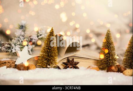 Alberi di Natale fatti di filo e libro aperto con pagine piegate come un cuore nella decorazione natalizia Foto Stock