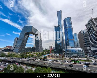 Pechino, Cina - 17 settembre 2025 : suggestivo edificio a forma di anello della sede centrale commerciale sorge tra eleganti torri di vetro in una vivace metropoli wi Foto Stock