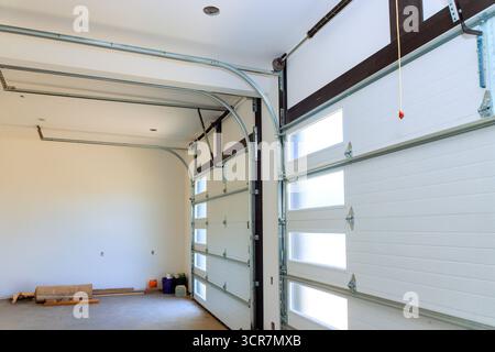 Il luminoso garage dispone di due grandi porte arrotolate, pareti semplici, perfette per riporre i bagagli Foto Stock