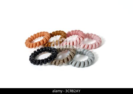 Un mucchio di lacci a spirale in vari colori neutri. Un concetto per accessori per capelli moderni, che prevengono pieghe e danni, e per una cura elegante dei capelli Foto Stock