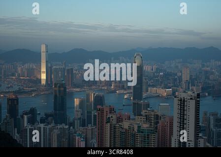Hong Kong, Cina - 2014: L'attuale giungla urbana dei grattacieli. Vista panoramica dello spettacolare skyline di Hong Kong e del porto di Victoria durante la nebbiosa sera al crepuscolo Foto Stock