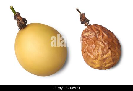 frutti della passione gialli, uno fresco e morbido, altri maturi e ruvidi, confronto di frutta che mostra le fasi di vita sfondo bianco isolato, vista ravvicinata Foto Stock