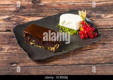 Ricco brownie al cioccolato con gelato alla vaniglia e frutti di bosco Foto Stock