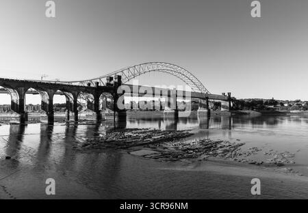 Vista in bianco e nero del Silver Jubilee Bridge e del viadotto ferroviario sul fiume Mersey Foto Stock