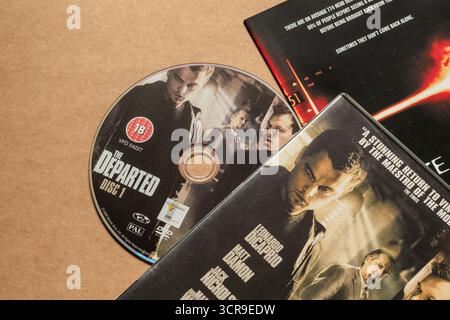 Disco DVD "The Departed" con copertina con attori principali, isolato su sfondo bianco chiaro, ripresa dall'angolo superiore Foto Stock