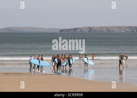 Un gruppo di vacanzieri in una lezione di surf con un istruttore della Cornish Wave Surf School presso Towan Beach a Newquay, in Cornovaglia, in Inghilterra Foto Stock