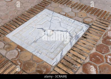 Una copertura di drenaggio quadrata decorativa incastonata in una passerella pavimentata in mattoni della necropoli di Shah-i-Zinda situata nella parte nord-orientale di Samarcanda, Uzbeki Foto Stock