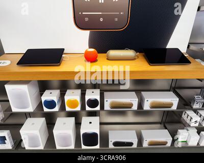 Manchester, Regno Unito - 29 settembre 2025: Esposizione al dettaglio con dispositivi Apple HomePod e casse disposte su un ripiano in legno. Foto Stock