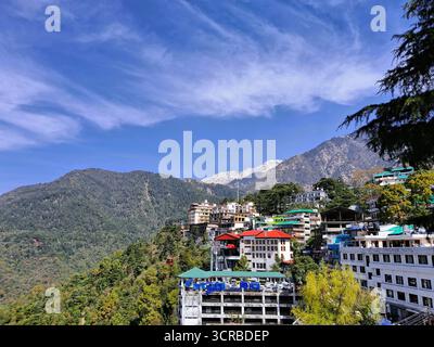 Splendida vista panoramica della città di McLeod Ganj dal complesso del Tempio Dalai Lama a Dharamshala, Himachal Pradesh, India. Si affaccia sulle maestose montagne Foto Stock
