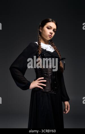 La ragazza vestita come personaggio del mercoledì sfoggia uno stile gotico durante la stagione spettrale di ottobre. Foto Stock