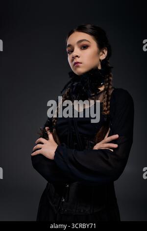 Una ragazza indossa un abito gotico del mercoledì con trecce, incarnando lo spirito di Halloween in ottobre. Foto Stock
