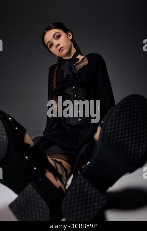 Una ragazza vestita con un costume gotico del mercoledì mette in mostra la sua creatività durante Halloween. Foto Stock