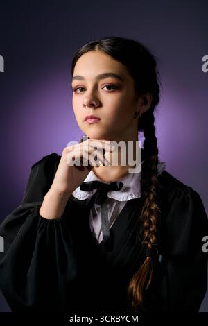 Una ragazza con trecce indossa un abito in stile gotico, evocando un inquietante personaggio del mercoledì per Halloween. Foto Stock