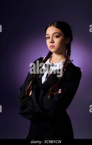 Una ragazza con trecce indossa un abito gotico mercoledì per Halloween, catturando perfettamente lo spirito spettrale. Foto Stock