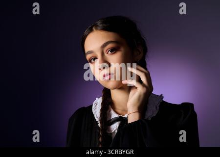 Una ragazza con trecce indossa elegantemente un abito gotico, catturando l'essenza del personaggio di mercoledì. Foto Stock