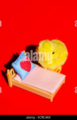 Pulcino piccolo cute che si prepara per andare a dormire nel suo letto. Concettuale. Foto Stock