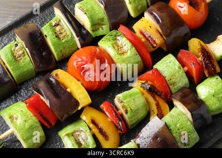 Barbecue vegetariano. Spiedini con gustose verdure grigliate sul tavolo, vista dall'alto Foto Stock