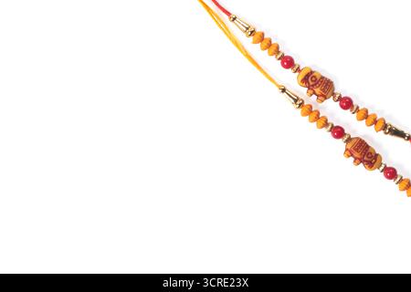 Braccialetto rakhi con perline rosse e decorazioni in oro, perfetto come regalo natalizio per Raksha Bandhan. Decorazioni tradizionali indiane Foto Stock