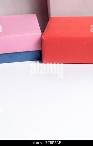 Le luminose confezioni regalo pastello in rosa, arancione e blu creano un'allegra esposizione perfetta per feste, regali e temi natalizi. Foto Stock