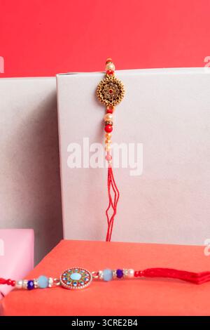 Un colorato gioiello tradizionale, con un elaborato medaglione d'oro e perle rosse e, è adornato su un audace sfondo rosa su un regalo bianco Foto Stock