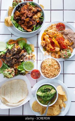 Una vista dall'alto verso il basso di diversi antipasti tex-mex su una superficie piastrellata del tavolo. Foto Stock