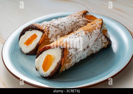 Cannoli su un piatto, ripieni di crema di ricotta e scorza d'arancia candita Foto Stock