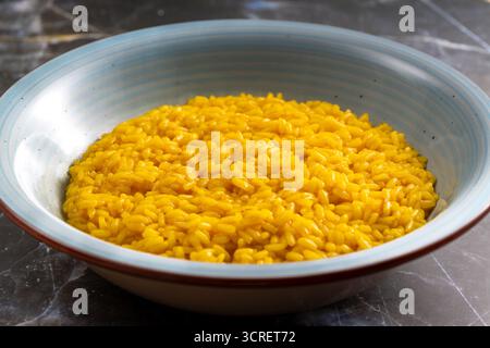 Cremoso risotto italiano che presenta un classico piatto gourmet su sfondo scuro Foto Stock