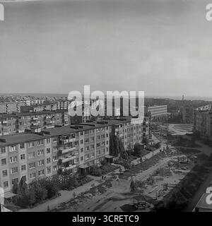 Un'ampia fotografia panoramica ad alto angolo degli anni '1980, che mostra il vasto microdistretto residenziale Artema a Sloviansk, RSS Ucraina. L'immagine cattura l'immensa scala della pianificazione urbana sovietica, con infinite file di blocchi di appartamenti standardizzati prefabbricati (panelka) che si estendono all'orizzonte. Sotto, i cortili tra gli edifici presentano parchi giochi e vegetazione sparsa. Questa visione d'archivio in bianco e nero è un esempio per antonomasia dell'architettura abitativa di massa monotona ma funzionale del tardo periodo sovietico Foto Stock