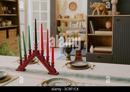 Portacandele Kwanzaa Kinara che mostra le candele accese sul tavolo delle feste Foto Stock
