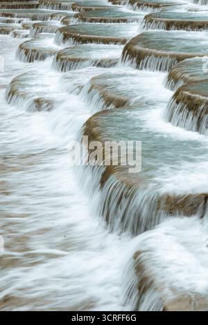 Vista dell'acqua turchese che scorre su formazioni terrazzate di travertino, creando un'affascinante scala naturale a Lijiang, Yunnan, Cina. Foto Stock