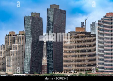 Moderni grattacieli curvi ed alti edifici residenziali sul lungomare di East River a Manhattan, New York, USA. Giugno 2025. Foto Stock
