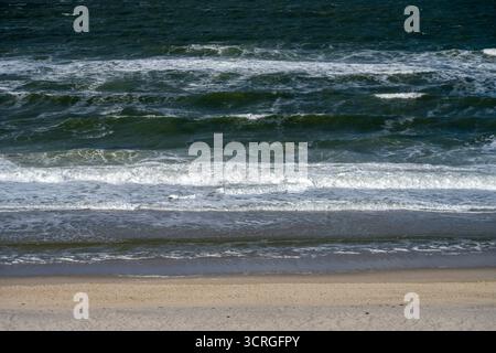 Reise auf die Insel Sylt. Blick in Kampen am Weststrand vom Roten Kliff aus hinab auf die aufgewühlte Nordsee und deren Wellen bei Flut. Nordfriesland Schleswig-Holstein Deutschland *** gita all'isola di Sylt View a Kampen sulla spiaggia occidentale dalla scogliera rossa fino al mare del Nord e alle sue onde con l'alta marea della Frisia settentrionale Schleswig Holstein Germania Foto Stock