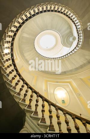 Guardando in alto la grande scala a chiocciola progettata da Antonio Cipolla all'interno dell'edificio della banca d'italia a Firenze Foto Stock