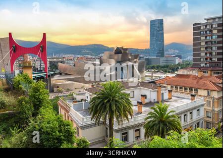 Bilbao, Spagna - 17 luglio 2025: Skyline di Bilbao al tramonto. Foto di viaggio colorate con il Museo Guggenheim, il ponte la Salve e gli edifici Foto Stock