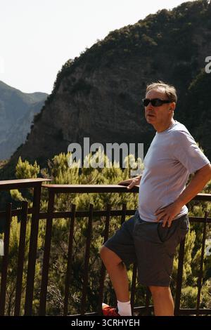 L'uomo anziano gode di una pausa tranquilla in un punto panoramico circondato dalla natura Foto Stock