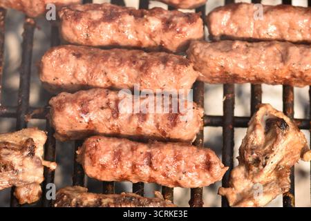 Mititei alla griglia, un piatto tradizionale rumeno. Si tratta di piccole salsicce di carne macinata senza involucro, di solito fatte con una miscela di manzo, maiale e agnello. Foto Stock