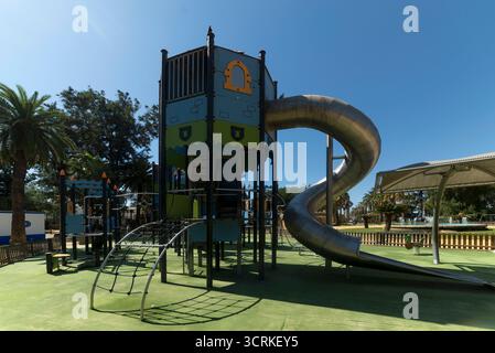 Parco giochi per bambini con altalene, scivoli, trampolini e aree per arrampicate Foto Stock