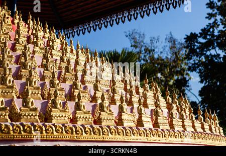 Wat Chomkao Manilat presenta numerose immagini dorate di Buddha disposte su file a più livelli a Huay Xai, Laos. Foto Stock