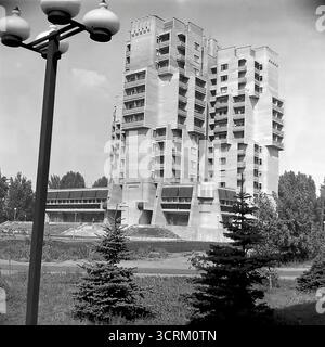 Una fotografia d'archivio in bianco e nero del 1988 di un edificio residenziale unico in Svobody Street a Sloviansk, RSS Ucraina. La struttura è uno spettacolare esempio di architettura sperimentale tardo-modernista sovietica e brutalista, un significativo allontanamento dai progetti abitativi standardizzati. Il suo design presenta una forma scultorea complessa con torri a incastro, balconi a sbalzo espressivi e una presenza monumentale. Situato all'interno di un parco paesaggistico, questo edificio era un punto di riferimento architettonico locale, mostrando un approccio più artistico e ambizioso alla pianificazione urbana in URSS Foto Stock