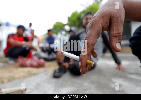 Gli uomini tengono sigarette con sfondo sfocato. Foto Stock