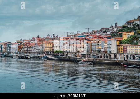 Vista panoramica delle colorate case residenziali storiche del quartiere di Ribeira e degli edifici tradizionali lungo il fiume Douro a Por Foto Stock