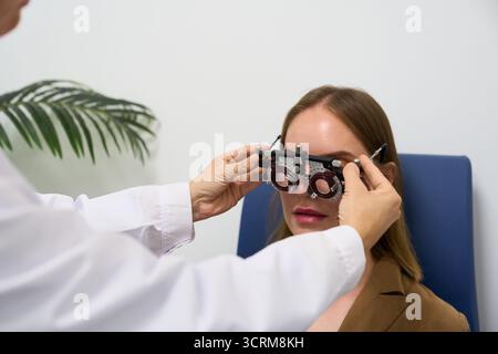 Optometrista che esegue l'esame oculare su pazienti con fanotrofio Foto Stock